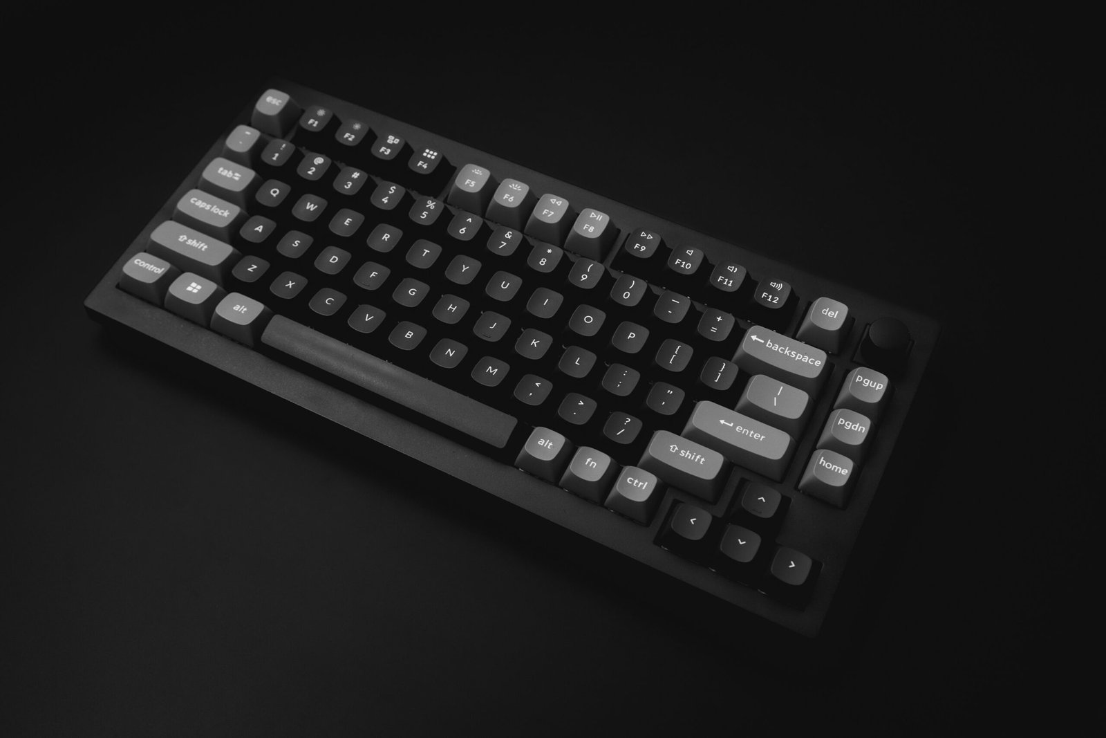 Computer keyboard on a black tabletop.